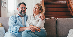 Happy older couple cuddling on couch