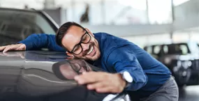 Family holding boxes moving into a new house